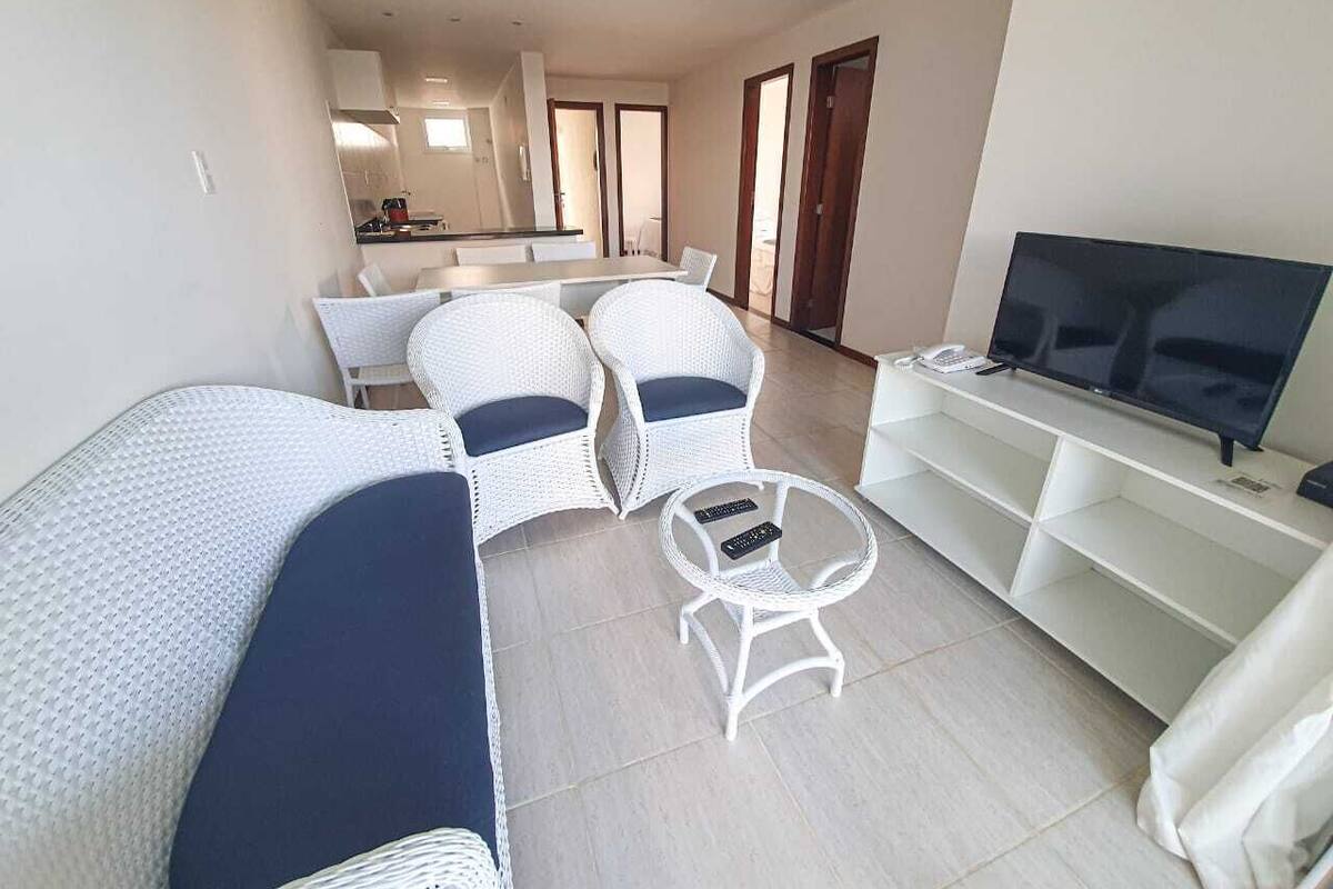 A modern living room with a sofa, two armchairs, a coffee table, and a TV stand.