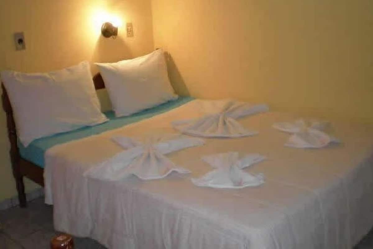 Un lit recouvert de draps et de serviettes blancs, soigneusement disposés.