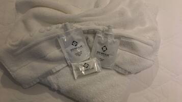 A bed with a white towel and three small white bags labeled 'Rede Mont Blanc'.