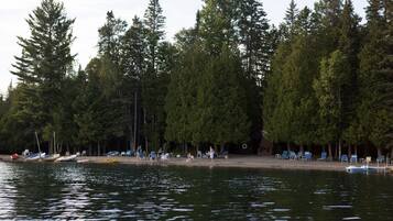 Relax by the serene lake with a row of beach chairs and a small rowboat at your disposal.