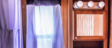 Une petite salle de bain comprenant des toilettes, un lavabo et un lambris en bois.