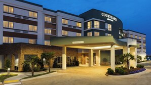 A Courtyard Marriott hotel with a covered entrance, clear signage, and a landscaped front area.
