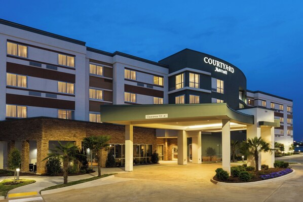 A Courtyard Marriott hotel with a covered entrance, clear signage, and a landscaped front area.