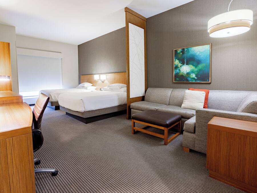 Een hotelkamer met een bed, een bank, een bureau en een stoel.