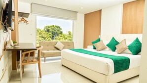 A modern hotel room with a bed, a sofa, a dining table, and a TV. - Solev Hotel (Villavicencio)