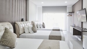 A hotel room with two beds, a TV, a desk, and a large window. - Solev Hotel (Villavicencio)