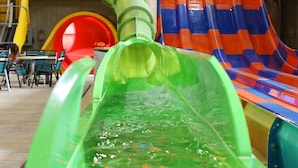 A water slide with a green tube leading to a red and blue slide. - Great Wolf Lodge Colorado Springs (Colorado Springs)