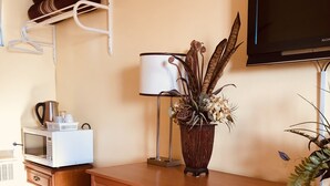 A wooden desk with a built-in mini-fridge, a lamp, and a decorative plant. - Martin's Inn (Cornwall)