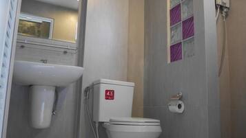 A modern bathroom with a toilet, sink, and shower.