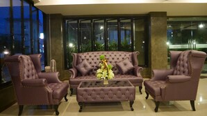 A modern lobby with a tufted sofa set, two armchairs, and a coffee table. - Green Garden Place (Udon Thani)