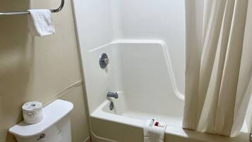 A bathroom with a toilet, a bathtub, and a shower curtain.