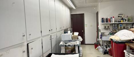 A clinical room with lockers, a bed, and medical supplies.