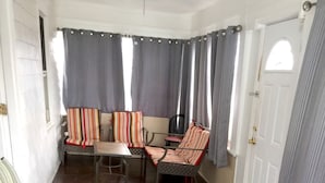 A room with a tiled floor, striped chairs, a table, and curtains. - HC-55 Beach Haus (Seaside Heights)