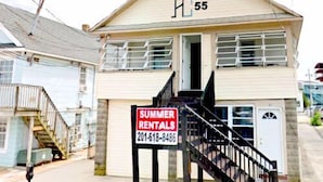 A two-story building with a 'H55' sign on the roof, a 'SUMMER RENTALS' sign, and a phone number. - HC-55 Beach Haus (Seaside Heights)