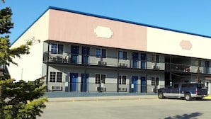 A multi-story motel with a flat roof, balconies, and a parking lot. - Little Bear Motel (Green River)