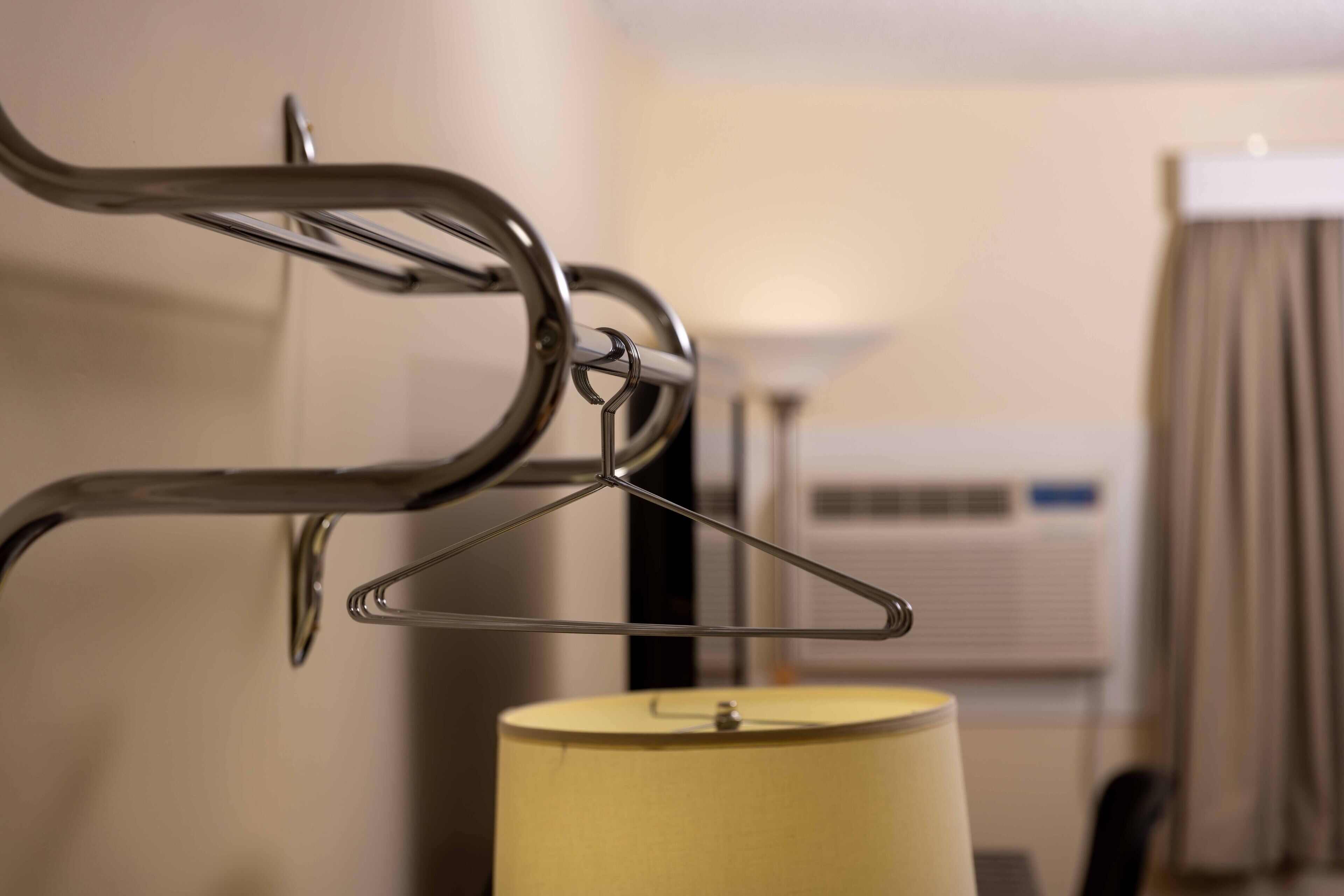 Habitación de hotel con cama, lámpara y aire acondicionado instalado en la pared.