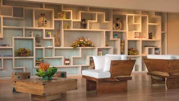 A modern living room with a geometric shelving unit, a wooden coffee table, and two wooden sofas.