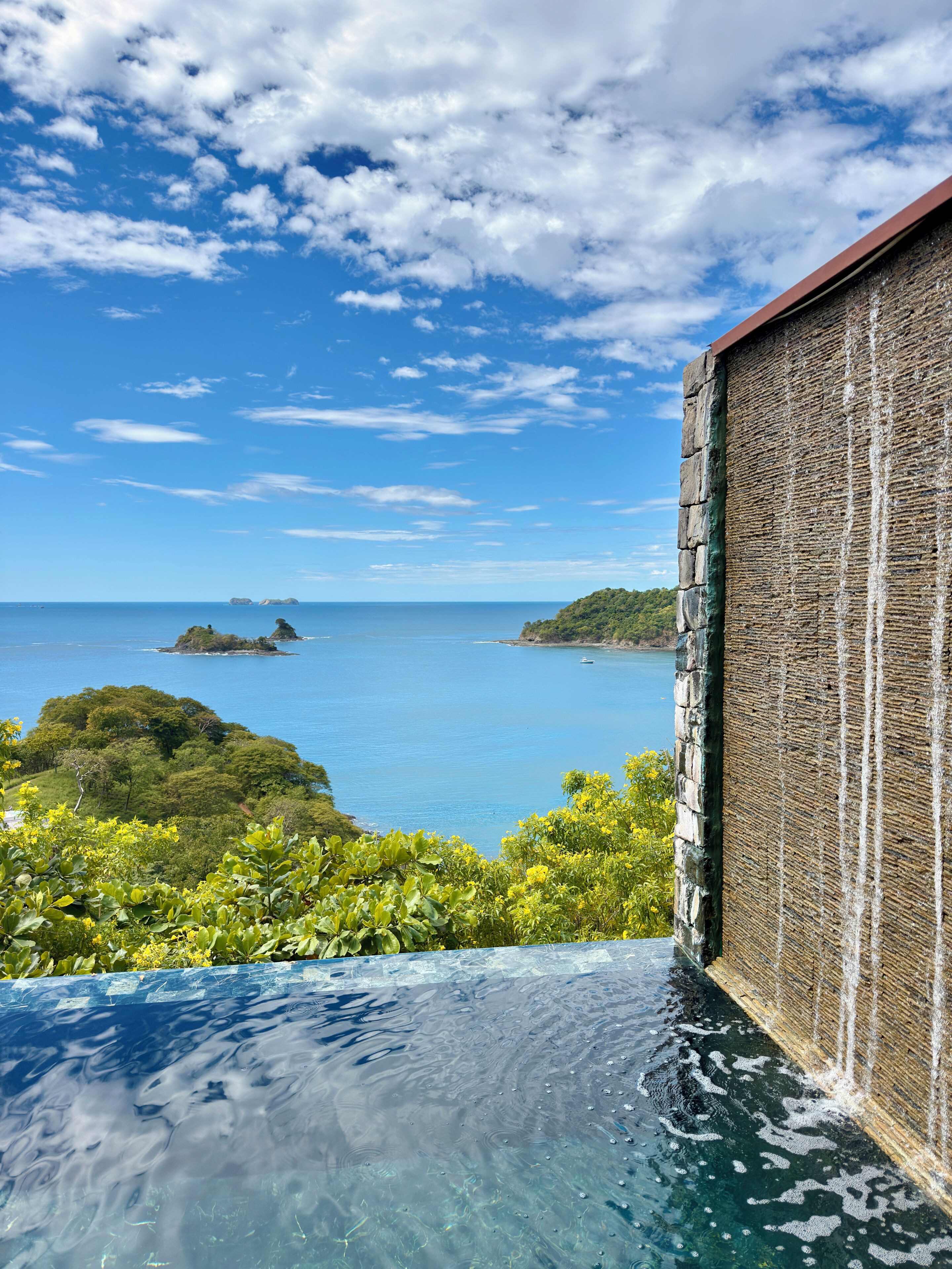 An infinity pool with a clear view of the sea and islands.