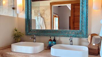 A bathroom with two sinks, a large mirror, and a decorative wooden vanity.