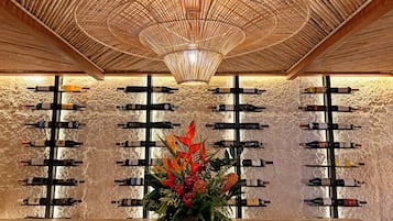 A wine cellar with wooden racks and a central floral arrangement.