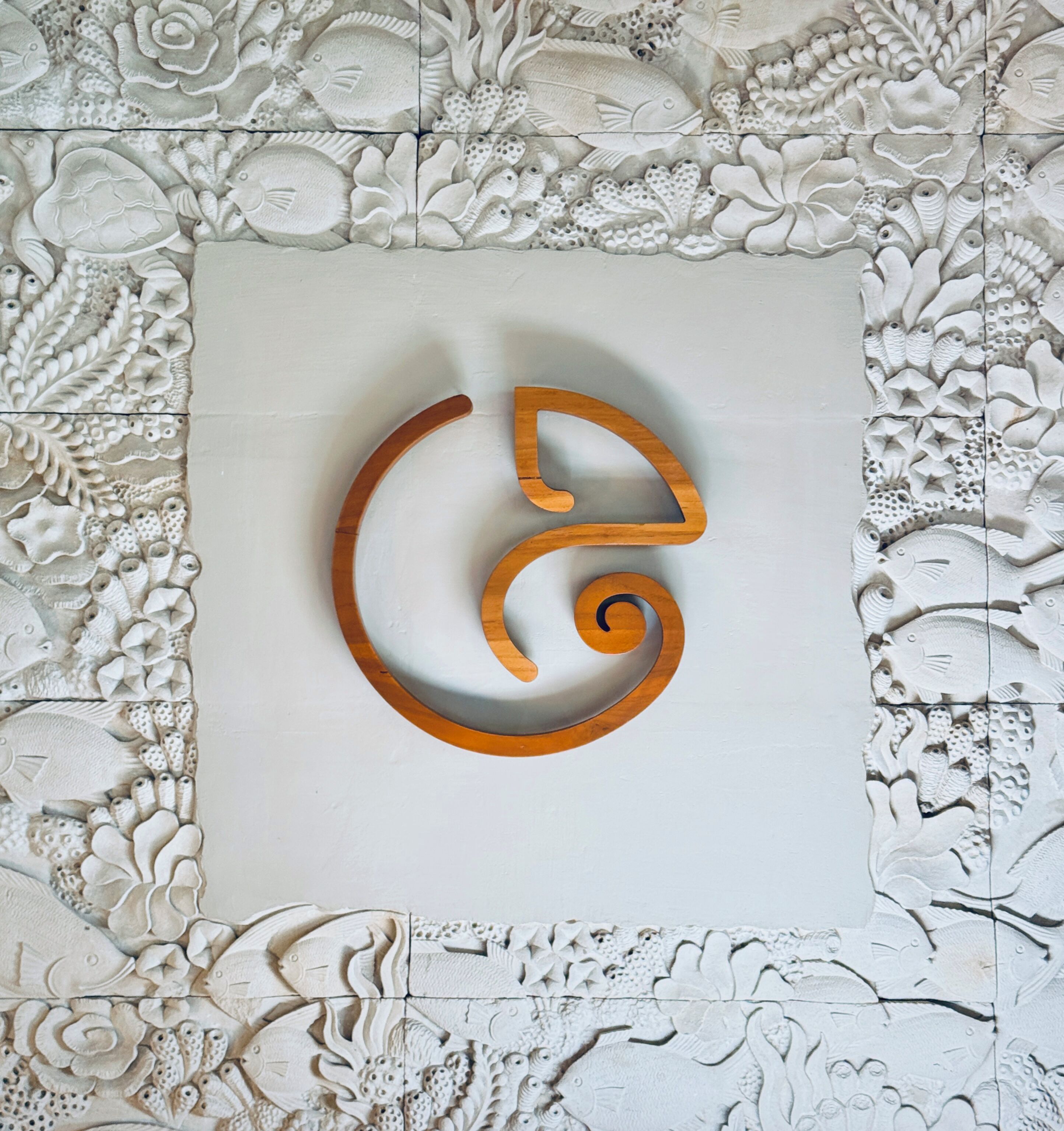 A wall with a central square panel featuring a stylized, abstract design.