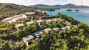 A resort with multiple buildings, a beach, and a bay.