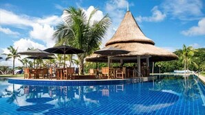 A swimming pool with a thatched-roof pavilion and lounge chairs. - Cove Resort Palau (Malakal Island)