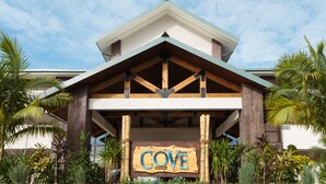 A resort building with a prominent 'COVE' sign, wooden beams, and tropical landscaping. - Cove Resort Palau (Malakal Island)