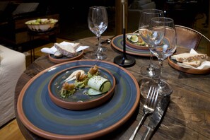 A dining table set with plates, glasses, and cutlery. - Hotel Raudal (Palena)
