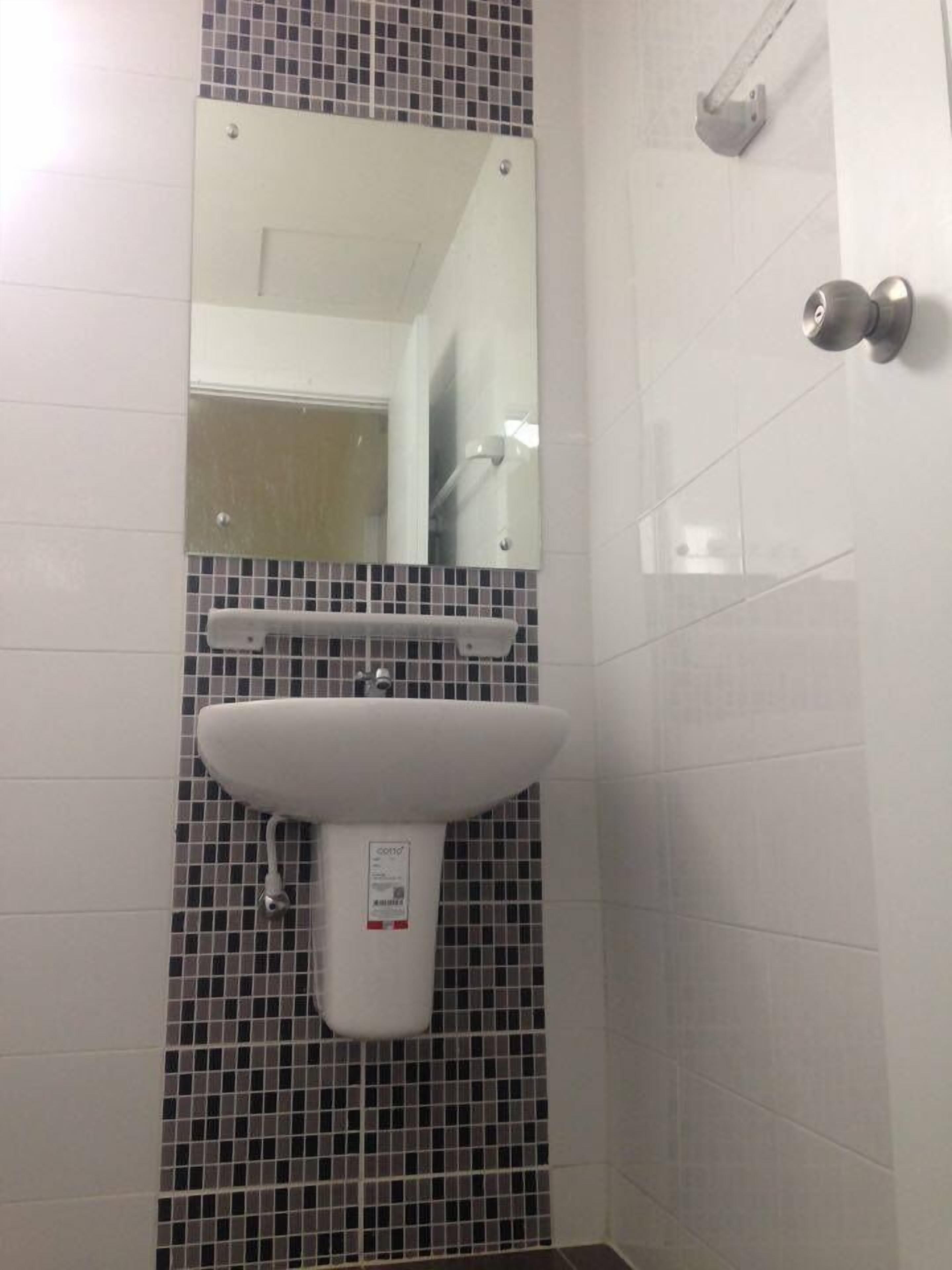 A bathroom with a white sink, a mirror, and a shower.