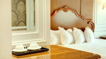 Een hotelkamer met een houten nachtkastje, een bed met witte beddengoed en een hoofdbord.