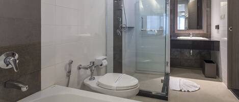 A modern bathroom with a glass-enclosed shower, a bathtub, and a toilet.