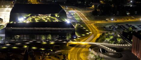 A large, modern building with a unique, curved roof structure.