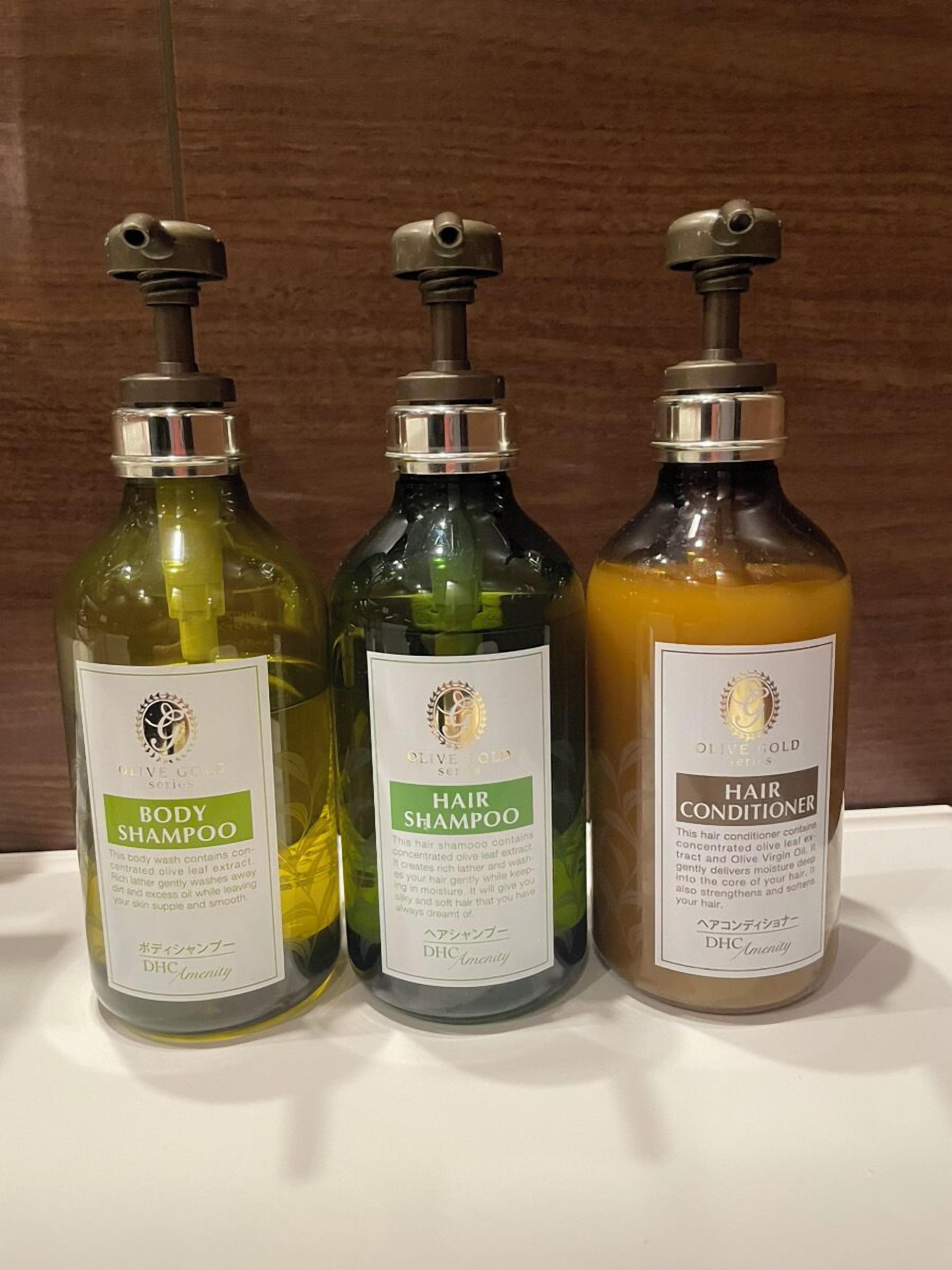 Tres botellas de productos para el cuidado del cabello sobre una superficie blanca.
