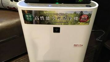 A white appliance with a digital display and stickers indicating it is a high-performance air purifier.