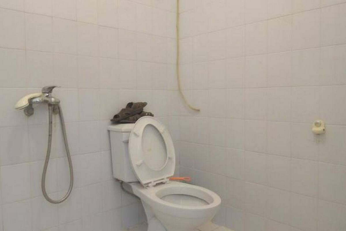 Un baño con inodoro, ducha y secamanos.