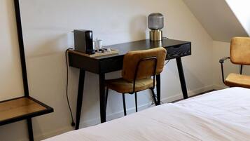 Un dormitorio moderno con una cama, un escritorio y una silla.