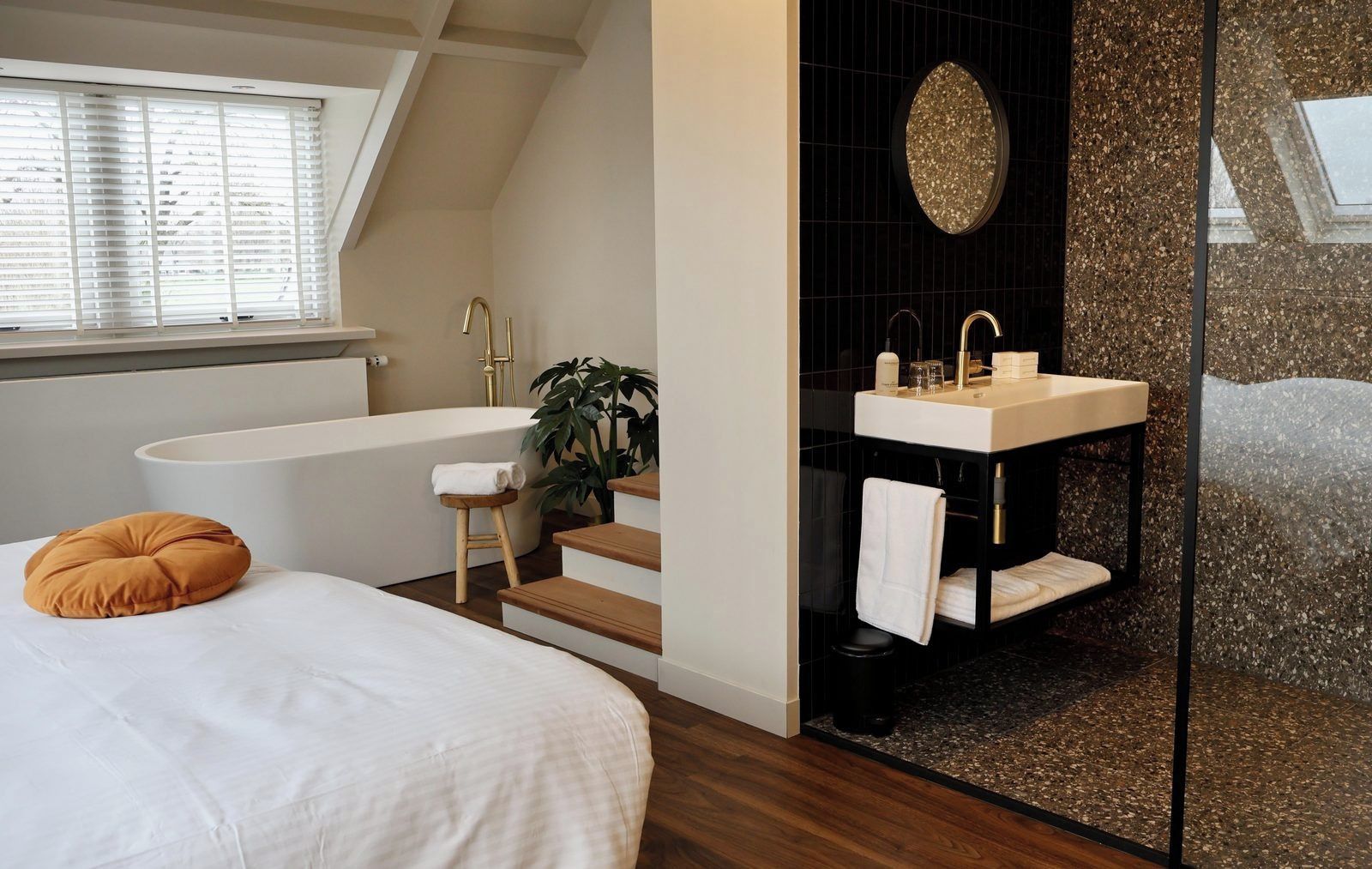 A modern bathroom with a freestanding bathtub, a vanity with a sink, and a large mirror.