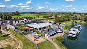 A riverside hotel with a dining area, a playground, and a boat dock. - Moeke Mooren (Appeltern)