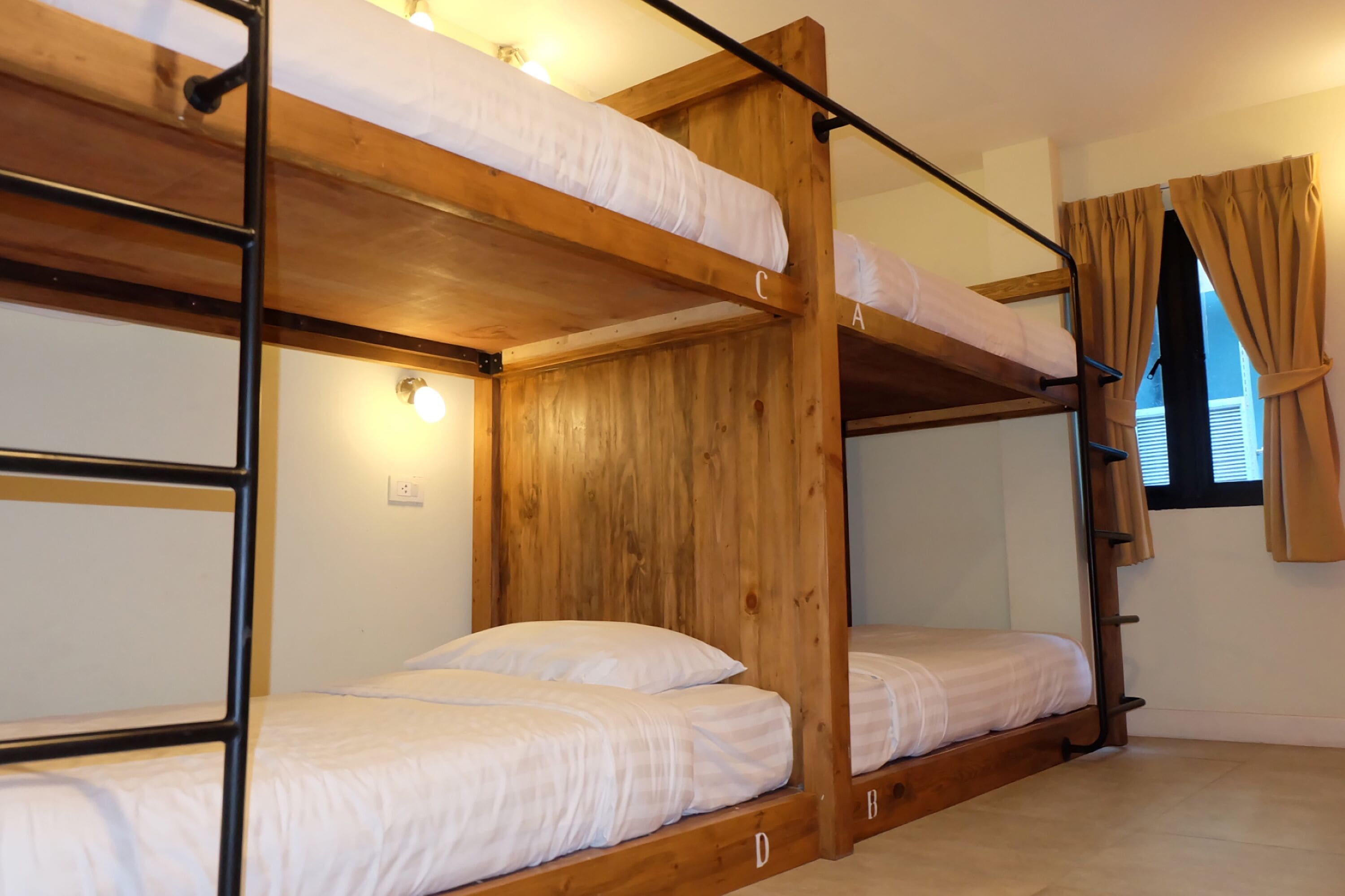 Dormitorio con literas de madera y ropa de cama blanca.