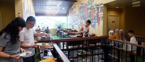 Una mesa de buffet con diversos alimentos y un mural en la pared.