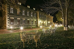 A historic stone building with multiple windows and a well-lit entrance. - Hotel Katerina Sarayi (Kars)