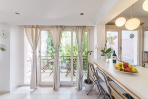 Apartamento, 1 quarto, vista para o jardim, no piso térreo | Cozinha americana privada | Geladeira, fogão, cooktop, cafeteira/chaleira