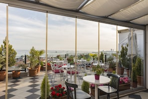 A terrace with checkered flooring, potted plants, and outdoor seating. - Istanbul Amedros Home (Istanbul)