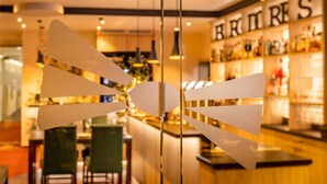 Un espace bar avec un comptoir et des étagères remplies de bouteilles.