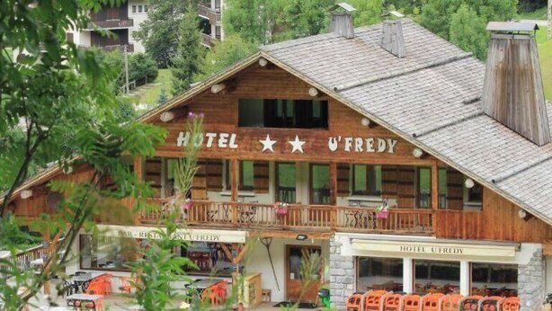 A wooden building with a sign reading 'HOTEL U'FREDY'. - Logis HOTEL Restaurant U'FREDY (La Clusaz)