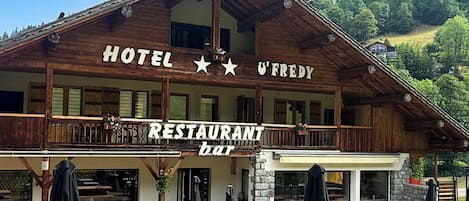 Un edificio de madera con un letrero que dice 'HOTEL U'FREDY RESTAURANT bar'.