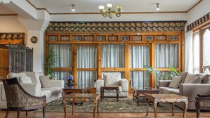 A traditional interior with wooden furniture, a patterned wall, and a chandelier. - Tiger Nest Resort (Paro)