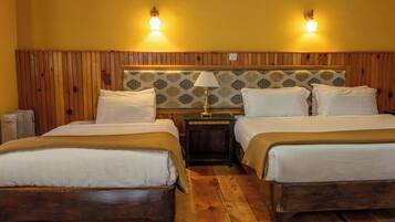 Habitación doble con dos camas, cabecero de madera, papel tapiz estampado, lámparas de noche y una alfombra decorativa.