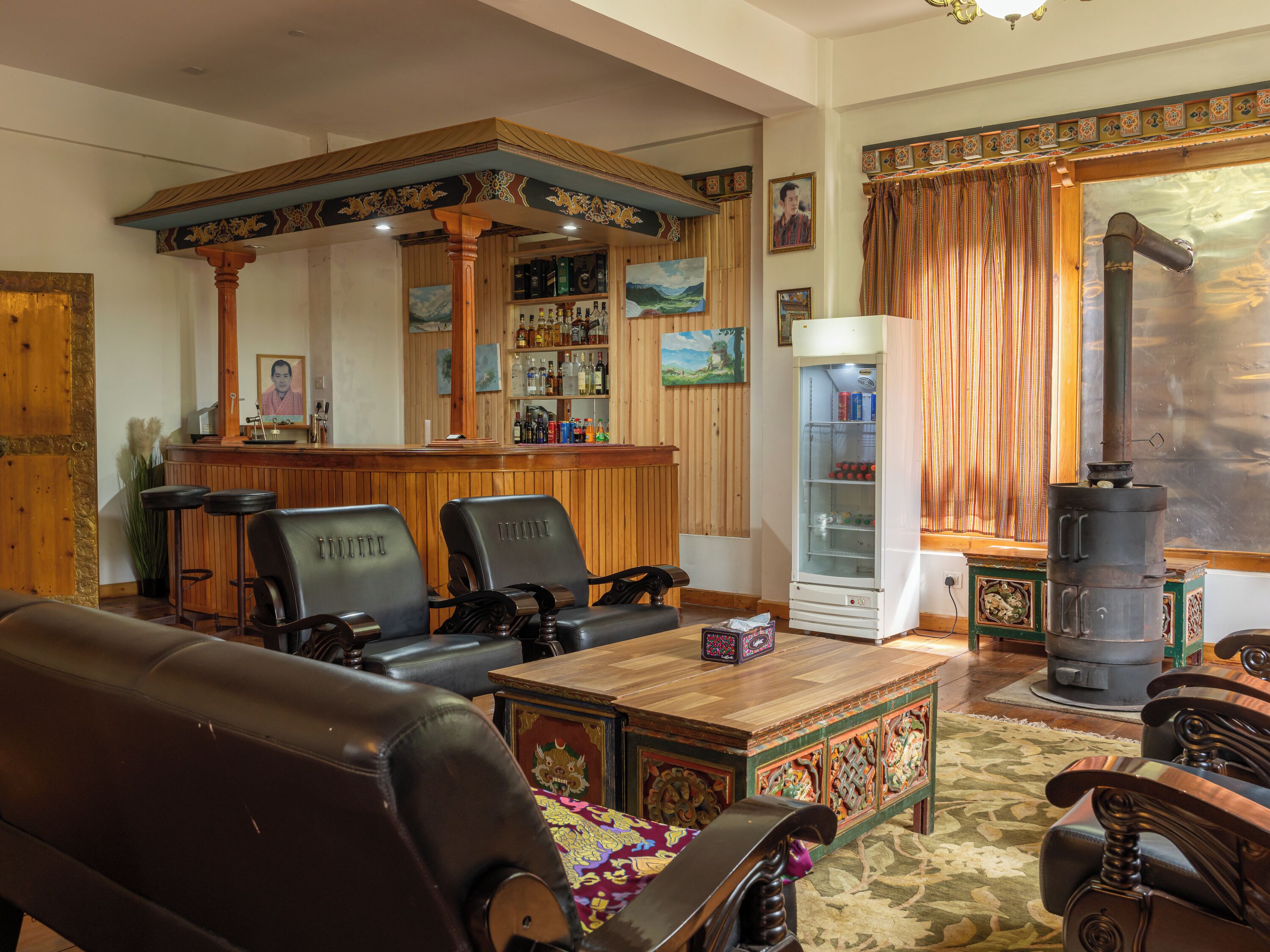 A traditional interior with wooden furniture, a bar area, and a decorative stove.